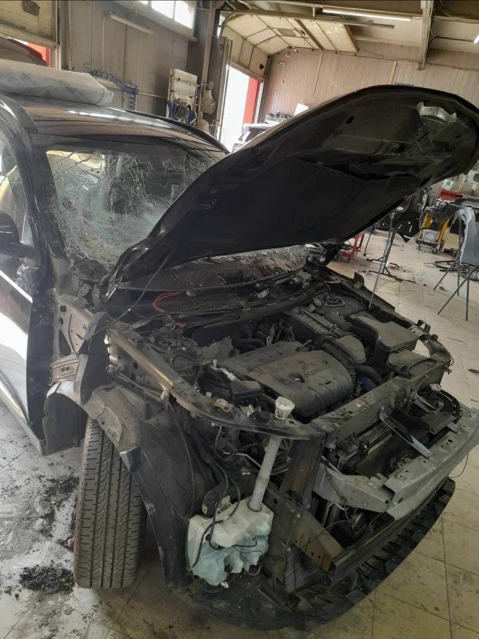 Оценка повреждений автомобиля после катастрофы. Подкапотное пространство и двигатель не повреждены, а кузовные элементы можно восстановить или заменить